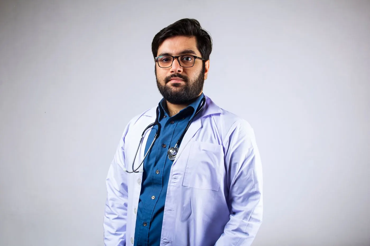 A doctor in a white coat with arms crossed