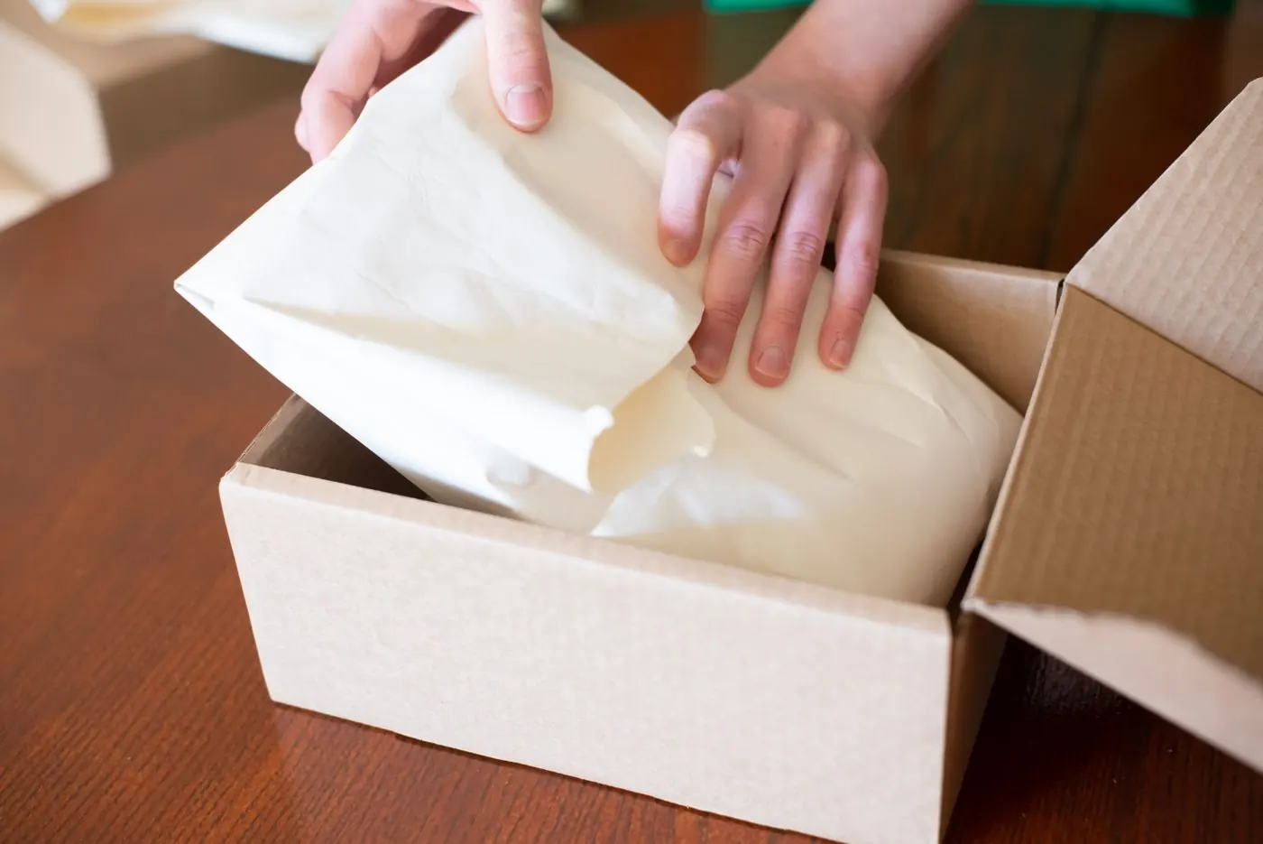 Hands packing a product into a box