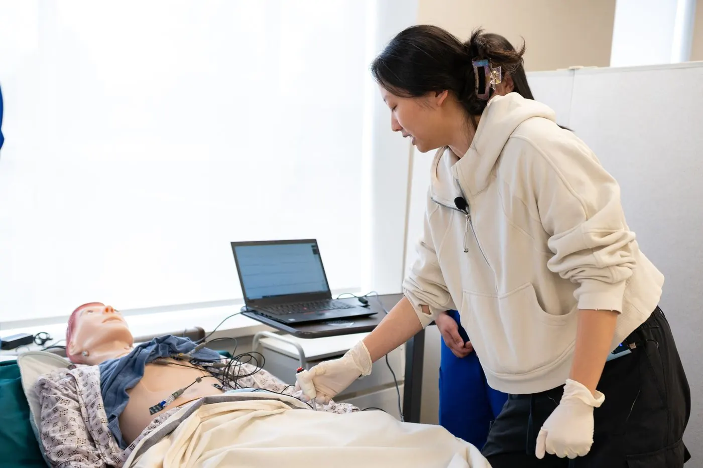 A nursing student practising on a training mannequin